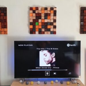 Art diffúzor egy modern TV-s nappaliban, ahol a 3D fa felület karakteres keretet ad a képernyő környezetének Art diffúzor egy modern TV-s nappaliban, ahol a 3D fa felület karakteres keretet ad a képernyő környezetének